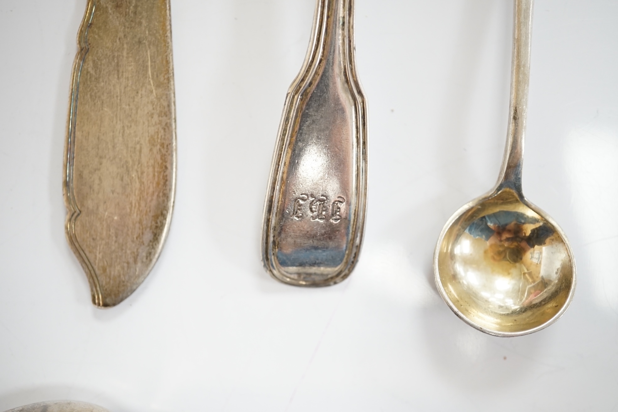 Ten assorted items of silver flatware including a mid 18th century mote spoon by Elizabeth Jackson?, 14.8cm, a George IV caddy spoons, two pairs of sugar tongs, four condiment spoons, a butter knife and sauce ladle, 6.8o